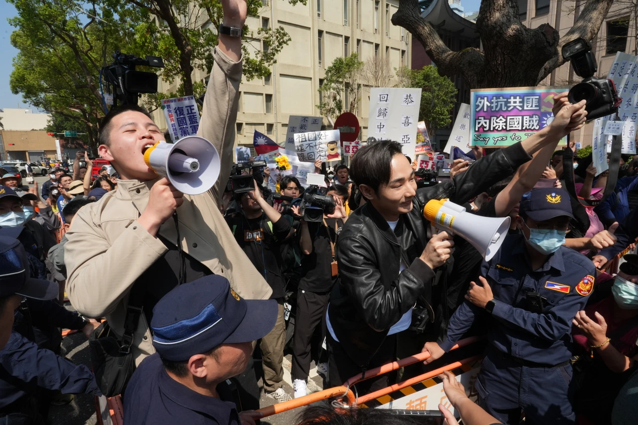 八炯(黑外套持擴音器者)與閩南狼(棕色外套持擴音器者)本是親密戰友,今年3月,兩人對著陸配亞亞大喊中國豬滾回去。資料照片,葉志明攝