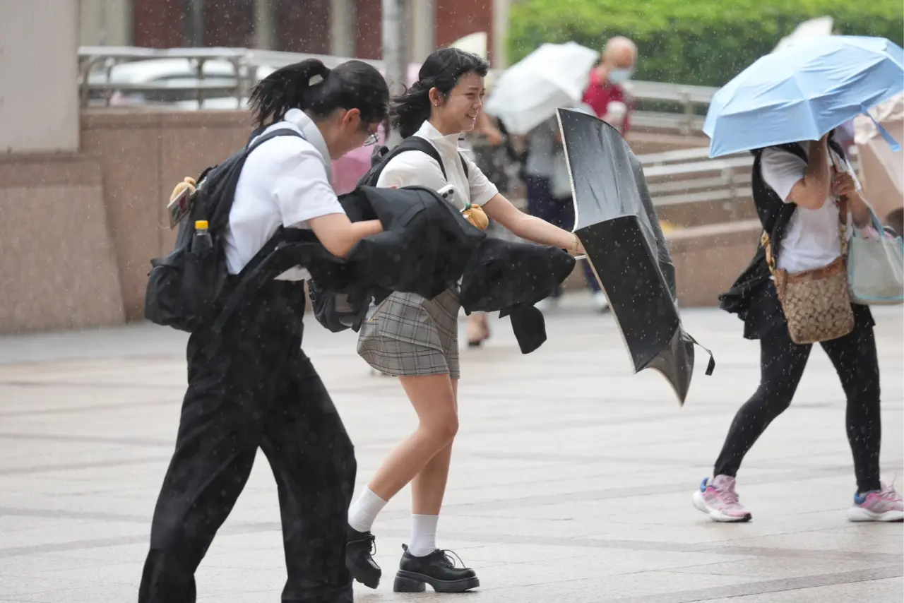 颱風丹娜絲的外圍環流持續對台灣造成影響,強風豪雨使通勤路人相當狼狽。資料照片,李柏毅攝