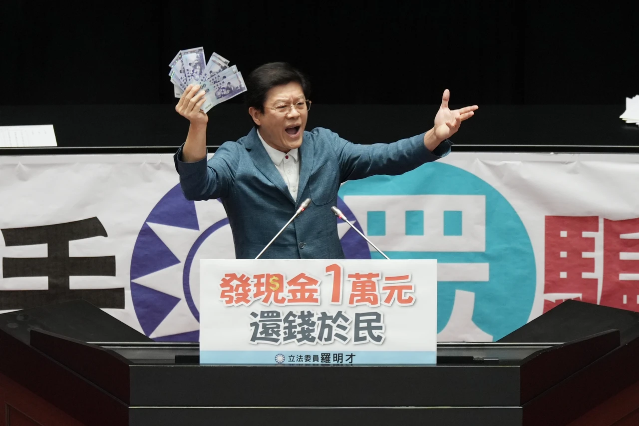 藍委羅明才高舉1萬元現金。資料照片,陳卓邦攝