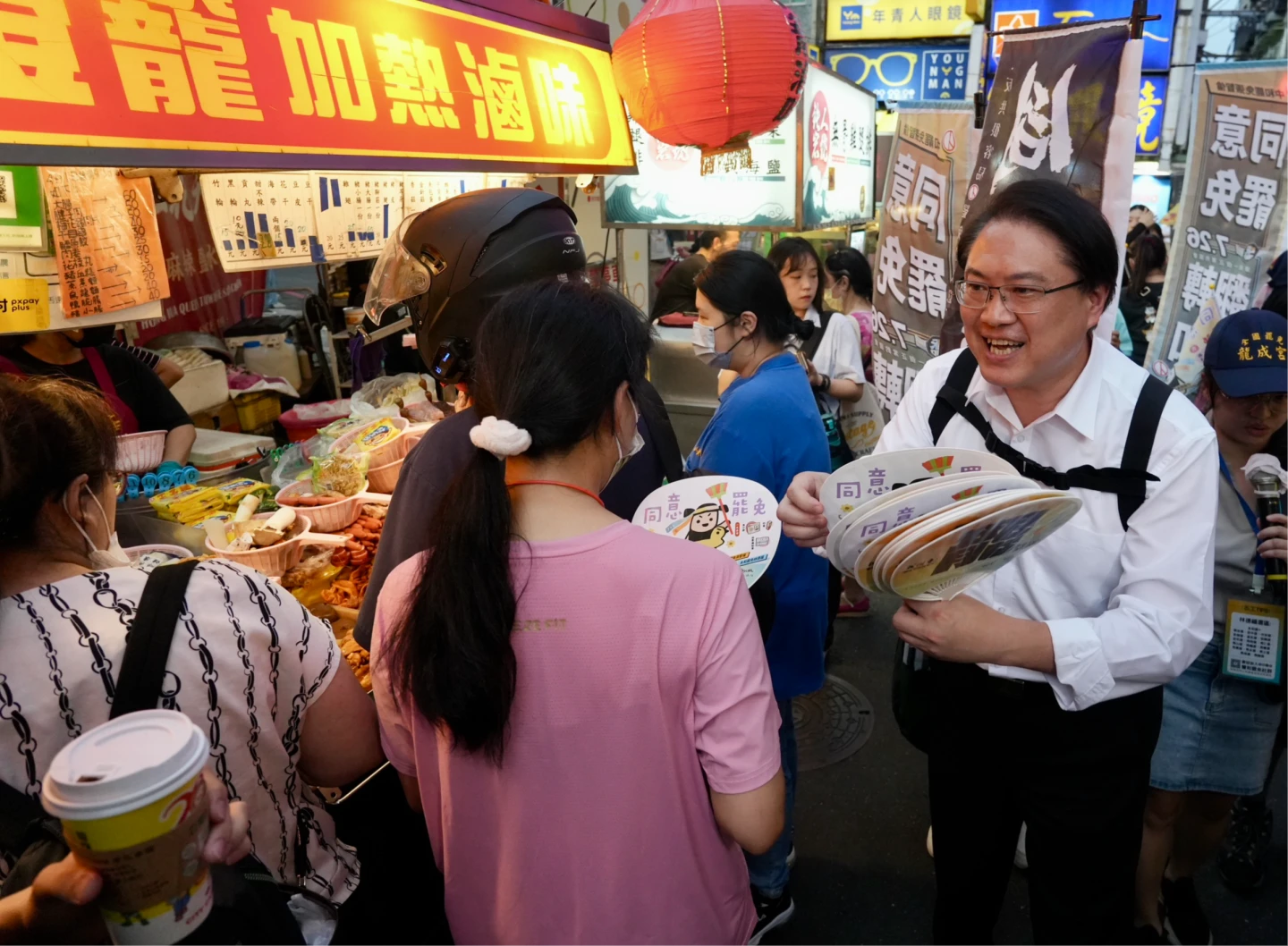 民進黨秘書黨林右昌揹同意罷免旗幟,在夜市沿攤拜票。梁建裕攝
