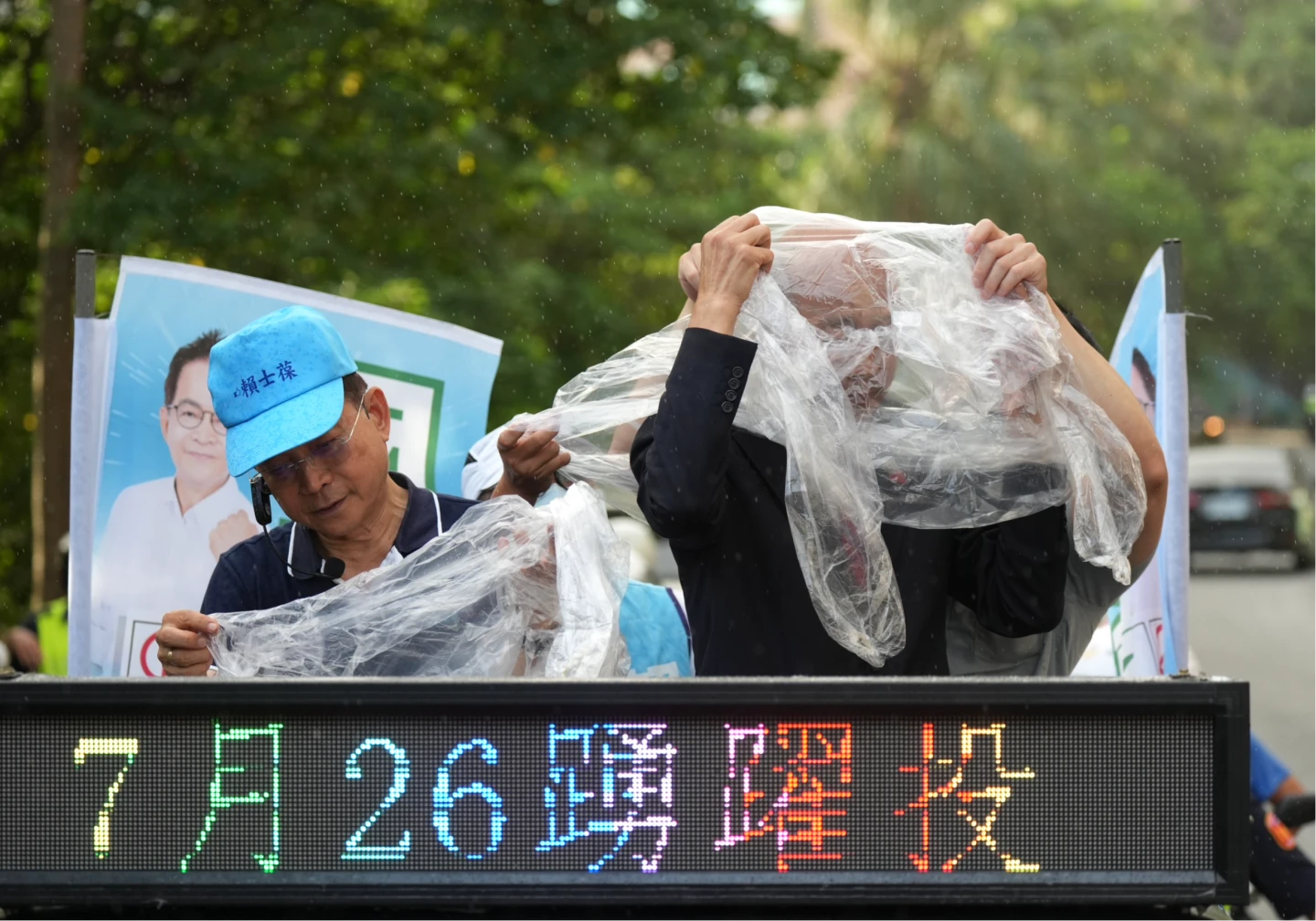車掃時遇到陣雨,韓國瑜穿輕便雨衣。梁建裕攝