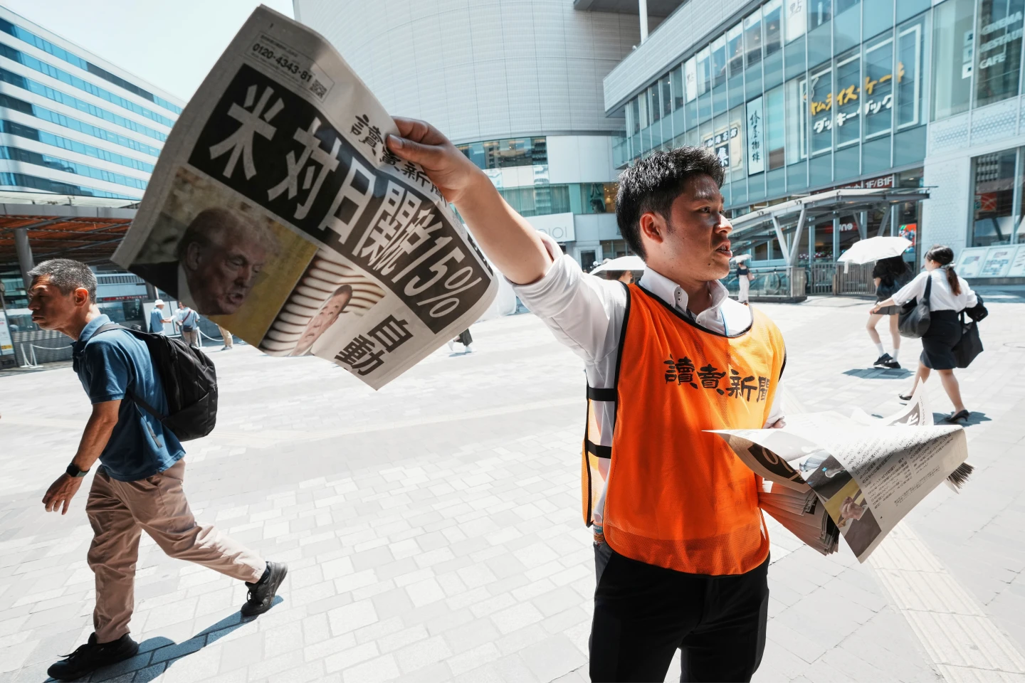 日本《讀賣新聞》人員7月23日在東京街頭,發送美日關稅協議的快報。美聯社