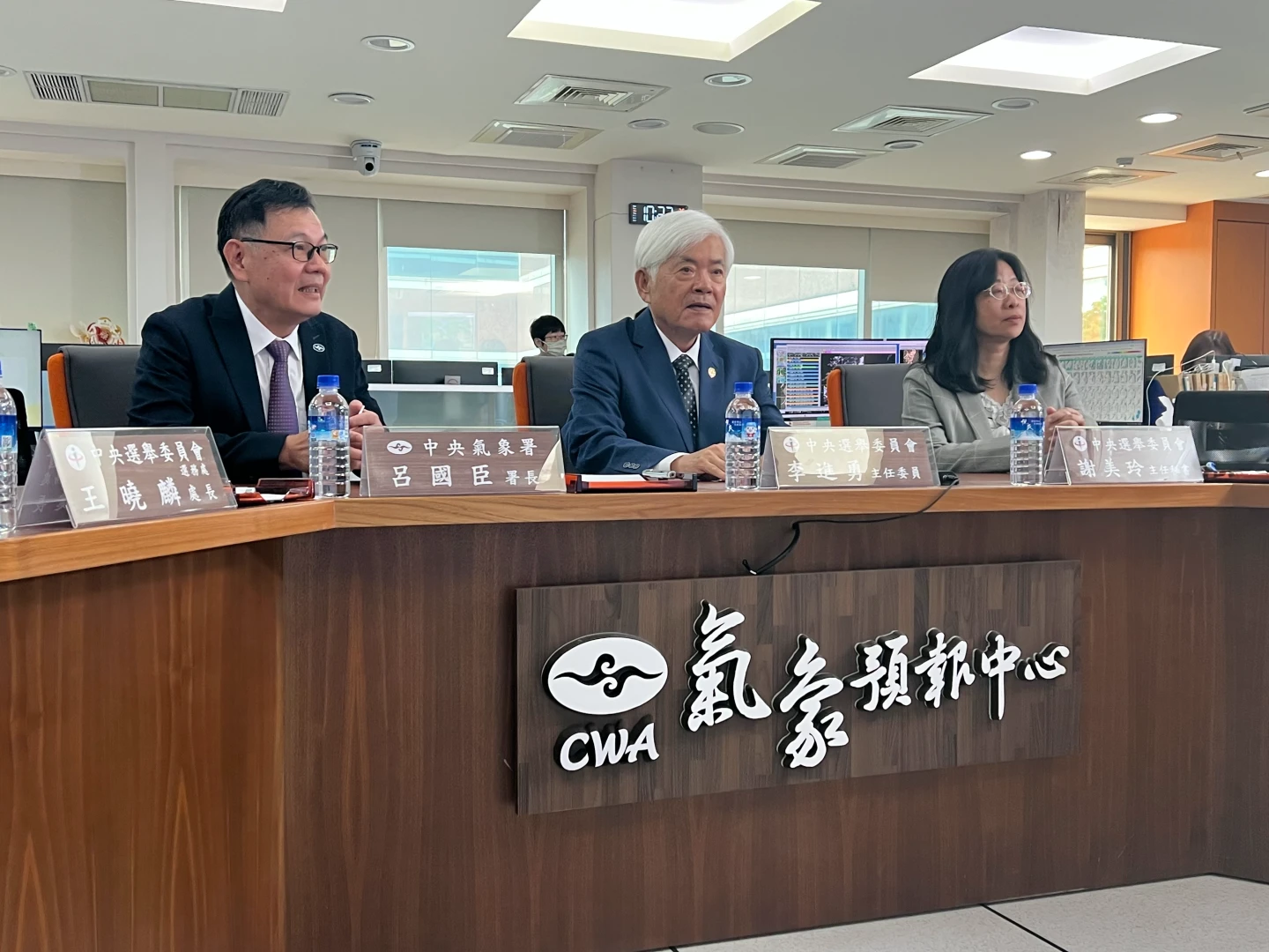 中選會主委李進勇(中)前往氣象署聽取颱風動態。中選會提供