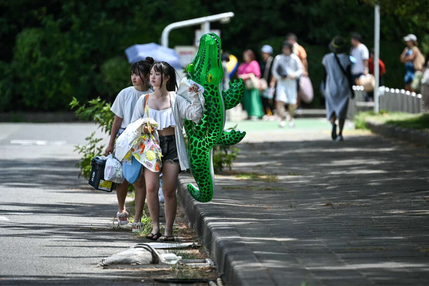 日本7月30日因應俄羅斯遠東強震發布海嘯警報,千葉縣稻毛海濱公園的遊客敗興離開。法新社
