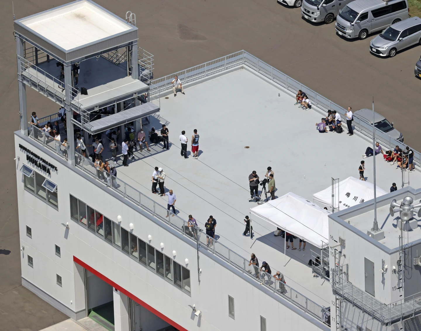 日本民眾7月30日在北海道木川町一處消防站的屋頂上避難。 美聯社