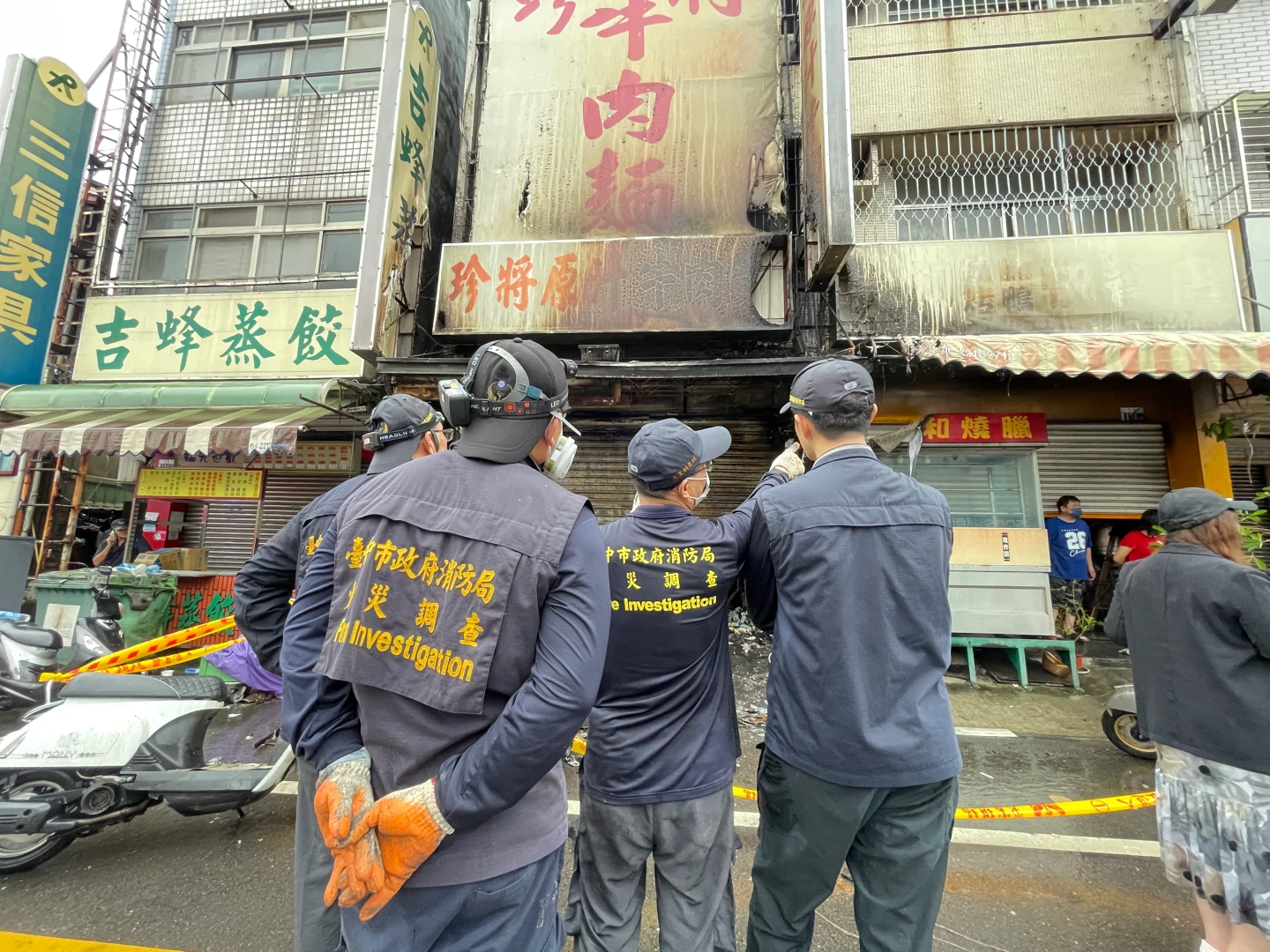 消防局火調人員站在火警現場討論。王煌忠攝