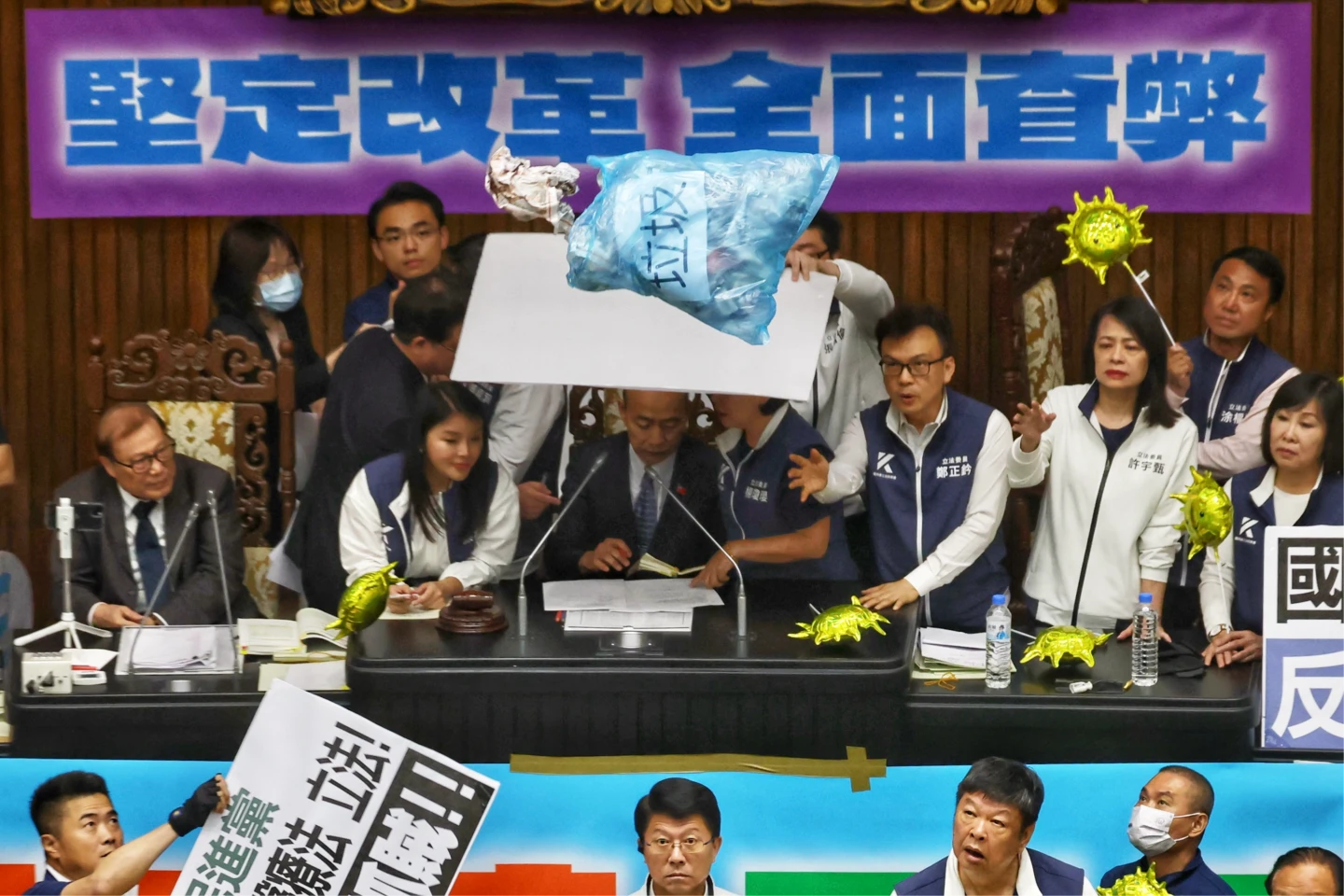 〈混沌之手〉5/藍白立委在主席台前舉布條抗議「國會改革法案」,綠營高喊口號並丟擲道具垃圾,主席韓國瑜遭波及。林林攝