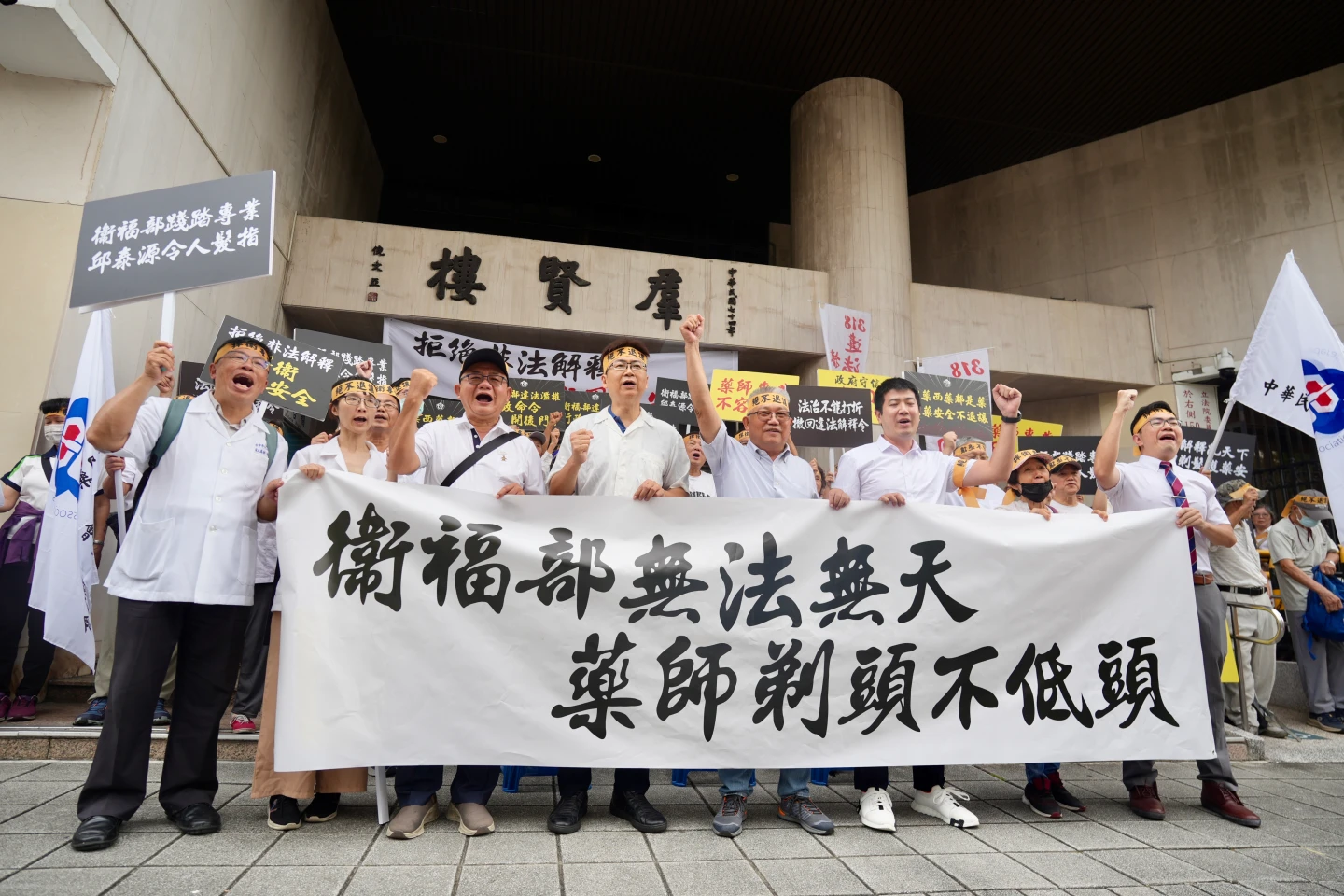 藥師公會全聯會到立法院快閃抗議,高舉「衛福部無法無天、藥師剃頭不低頭」布條。梁建裕攝