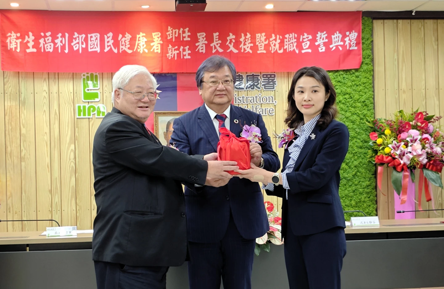 衛生福利部部長邱泰源(中)監交國健署新任署長沈靜芬(右)、卸任署長吳昭軍(左)交接。國健署提供