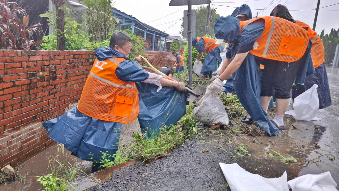 民進黨代理秘書長何博文(左)帶頭冒雨跳進水溝清淤。民眾提供