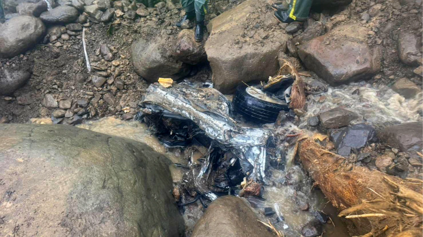 墜谷車輛慘遭土石擠壓變形。高雄市消防局提供