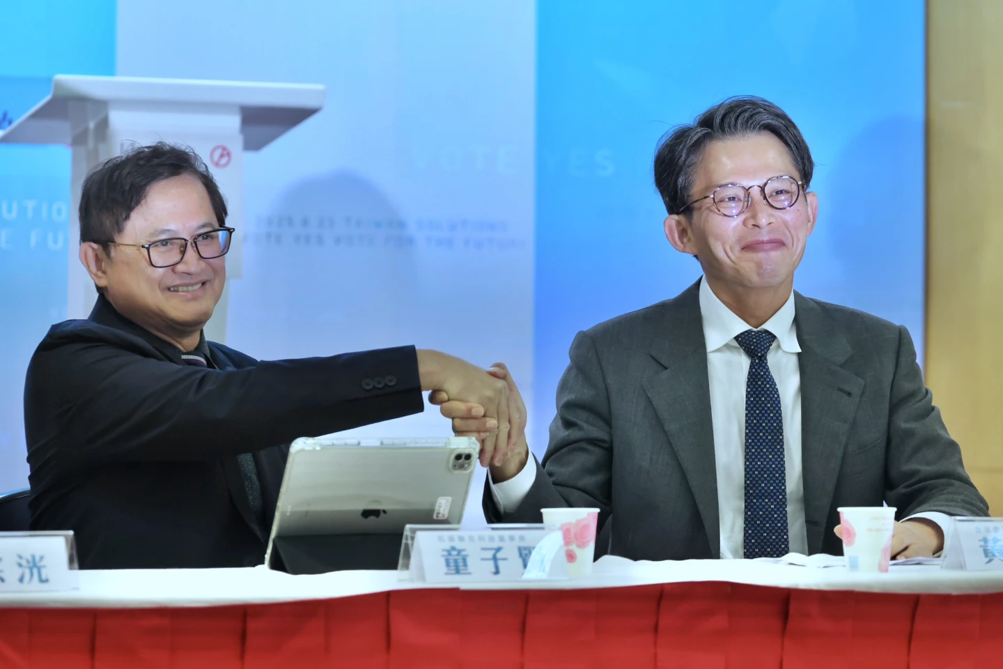 和碩董事長童子賢今早出席民眾黨「核三延役公投正聲亮」記者會,跟黨魁黃國昌握手合影。林林攝