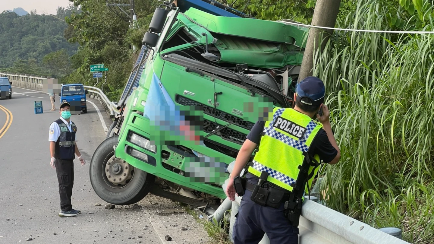 大貨車自撞電線桿,車體變形掉落水溝,駕駛朱姓男子受困車內。讀者提供