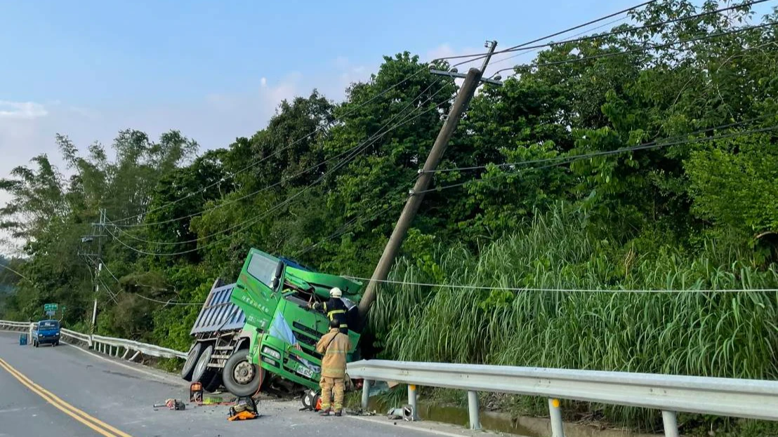 大貨車自撞電線桿,車體變形掉落水溝,現場電線桿傾斜。讀者提供