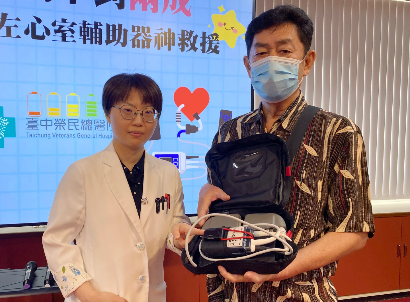 臺中榮總心臟血管外科醫師吳詠斯(左),說明長效型左心室輔助器透過皮膚穿出的電線連結外部電磁與控制器,供應全身血液循環。中榮提供