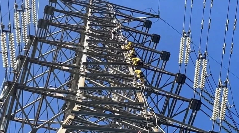 桃園市龜山區一處高壓電塔被發現有民眾吊掛在電線上且已死亡,消防局7日出動4名特搜人員爬上高壓電塔將人解下,死者疑為失聯外籍勞工。(翻攝照片)中央社