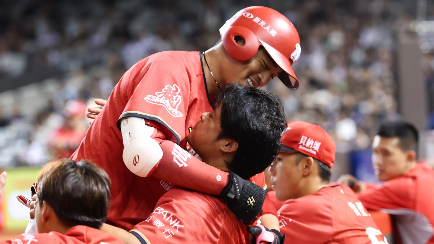 味全龍朱育賢(左)在原紀錄保持人林智勝(右)面前達成從新人年起連續10個球季達成雙位數全壘打。味全龍提供