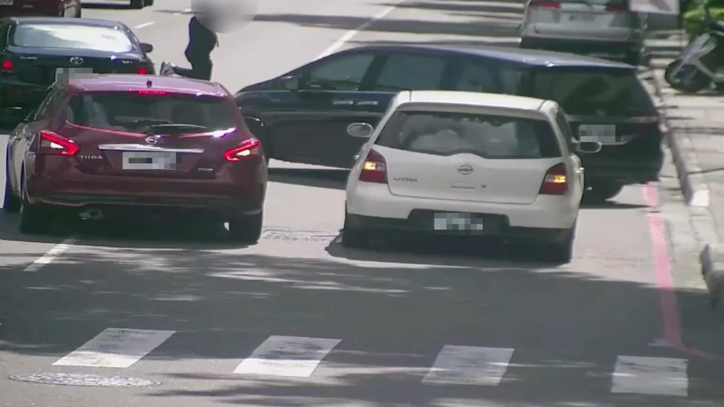 男子下跪在道路中央。讀者提供