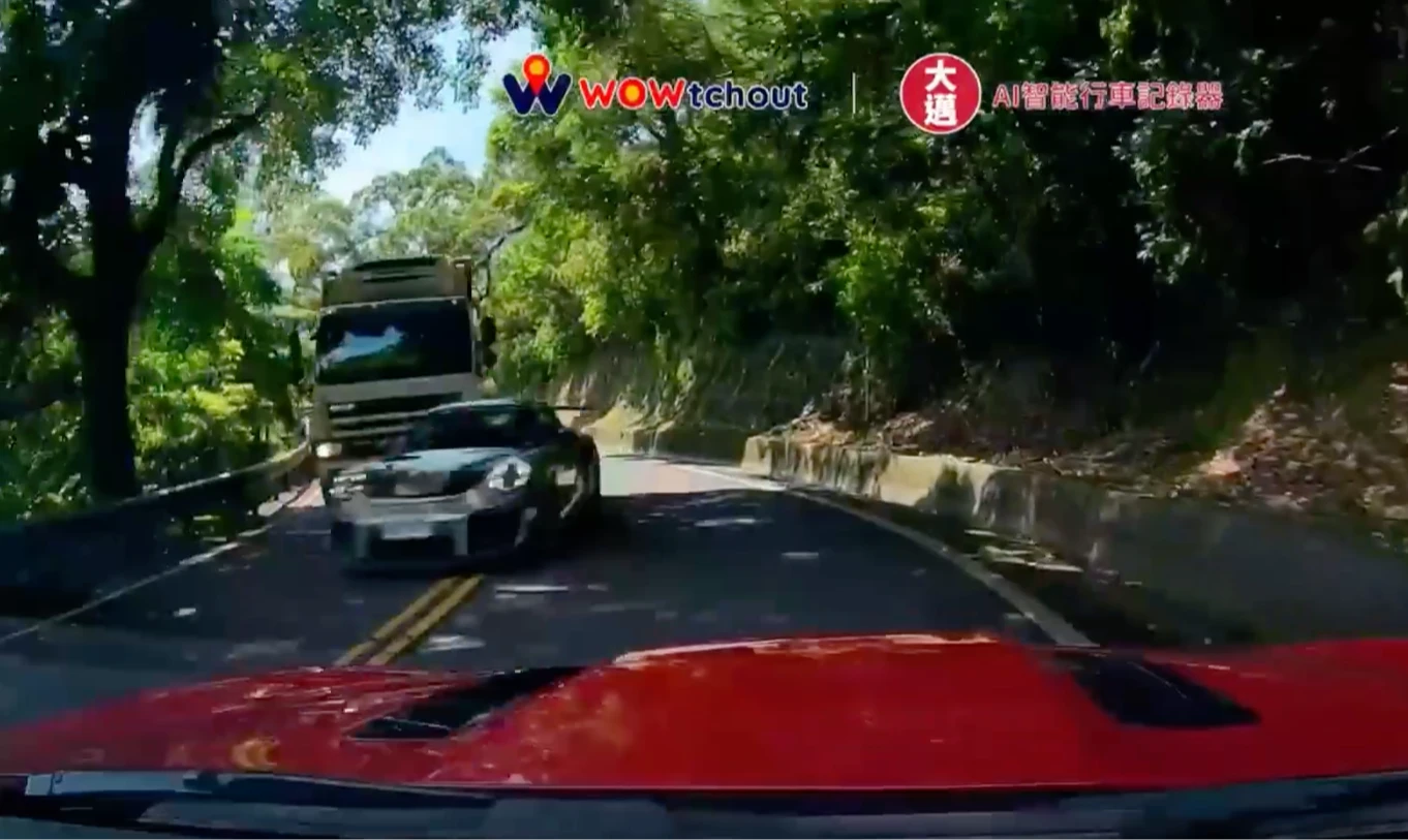 男子駕車正常行駛北宜公路,突遇對向保時捷超跑跨越違規跨越雙黃線逆向超車,害他險些被「擊落」,急忙煞車並向右側山壁避讓。後害者當天下午登門桃園保時捷中心質問駕車的黃姓業務員討公道。翻攝自YT頻道「WoWtchout - 地圖型行車影像分享平台」、臉書「車輛交通事故研究所」