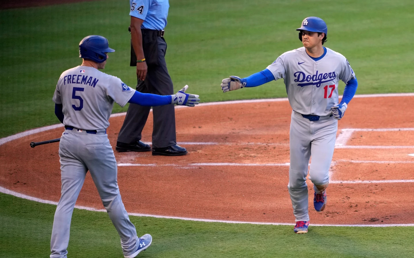 道奇隊大谷翔平(右)在首局敲出三壘安打後,再靠隊友安打跑回球隊第1分。美聯社