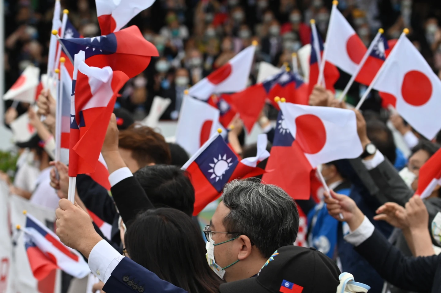 圖為2022年10月10日在總統府的國慶活動上,台灣和日本來賓揮舞日本國旗及中華民國國旗。