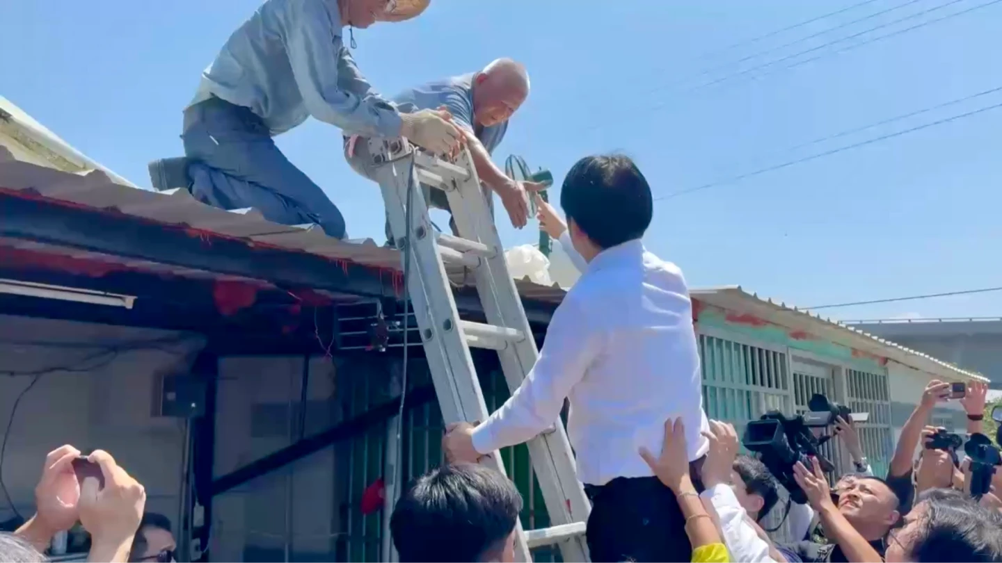 總統賴清德前往台南災區關心復原情形,一度爬上鋁梯,親自送水給工人。民眾提供