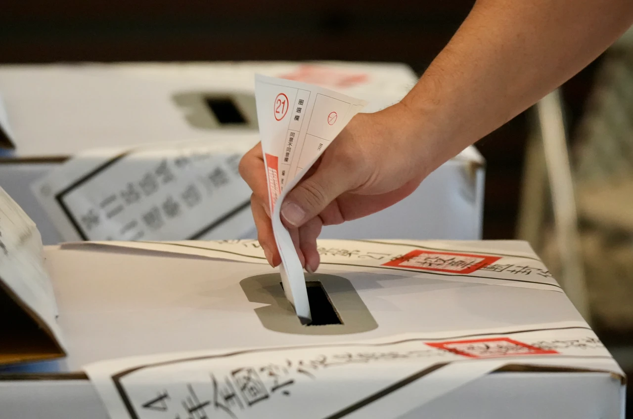 民眾把手中票券投入票匭。梁建裕攝
