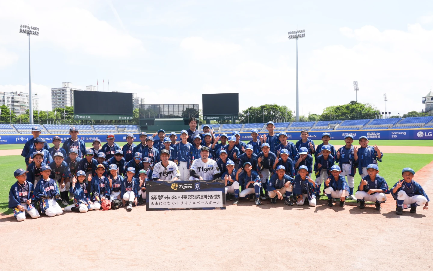 富邦悍將副領隊林威助與阪神虎球星鳥谷敬、秋山拓巳一同在棒球教室指導小球員。富邦悍將提供