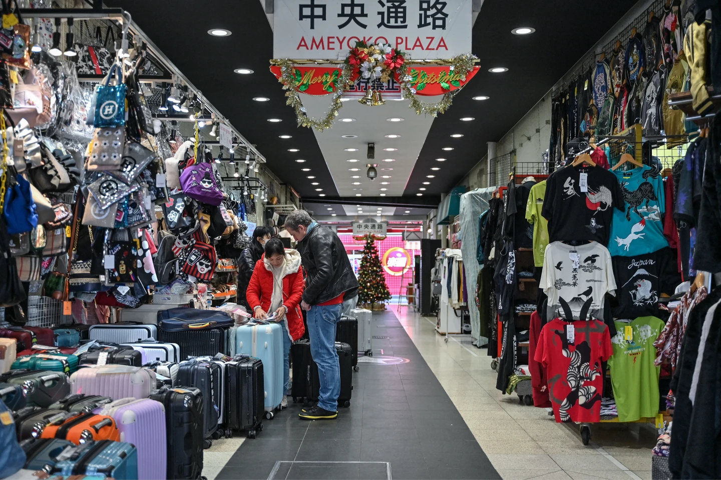 遊客在東京市中心上野地區的熱門觀光景點阿美橫丁市場行李箱店購物。資料照。法新社