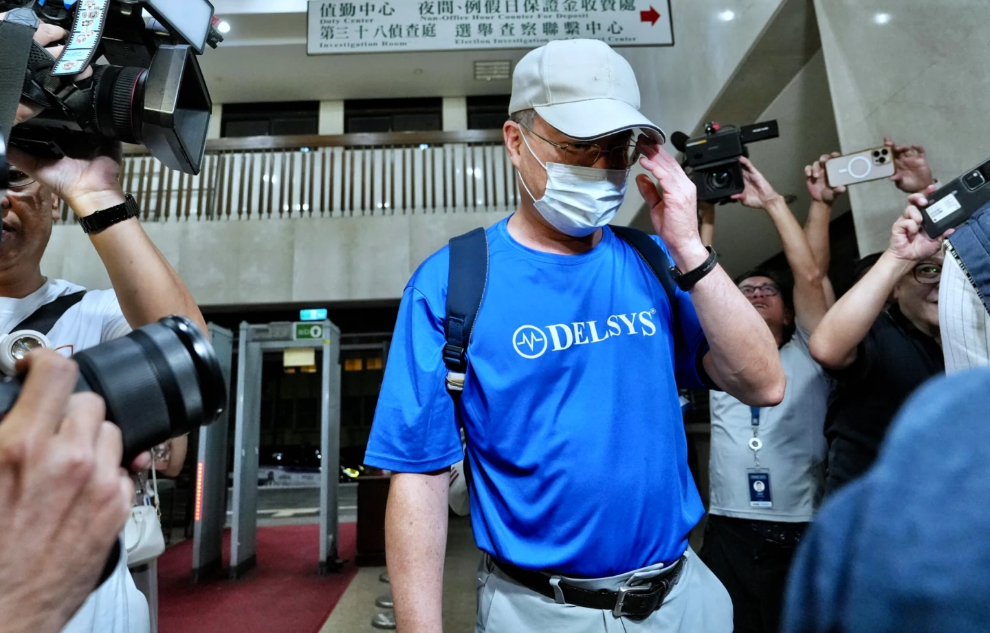 台師大教授陳忠慶被移送北檢複訊時,用手遮臉擋鏡頭。林林攝
