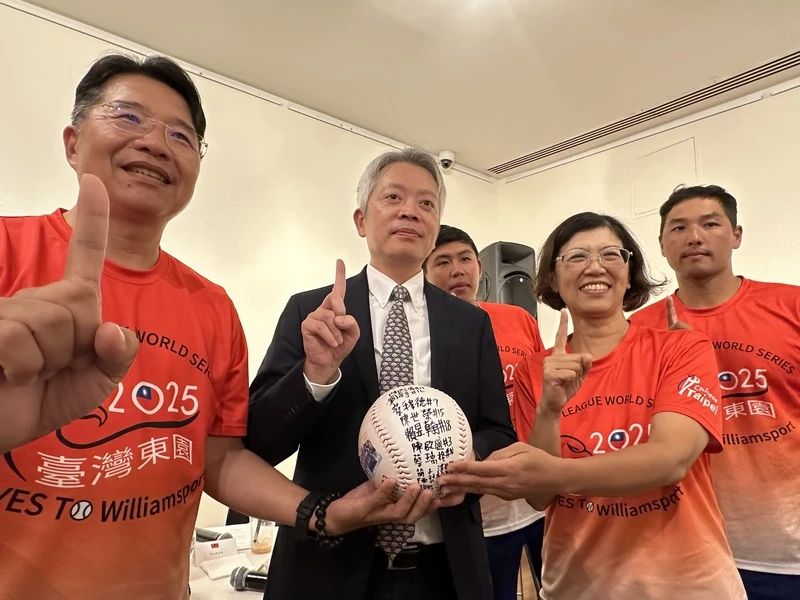 駐紐約辦事處長李志強(左2)拿出東園國小少棒隊10年前到訪的簽名球,與校長張鍾榮(左1)、前校長陳毓卿(右2)和「帥一下」教練駱政宇(右1)合影。中央社