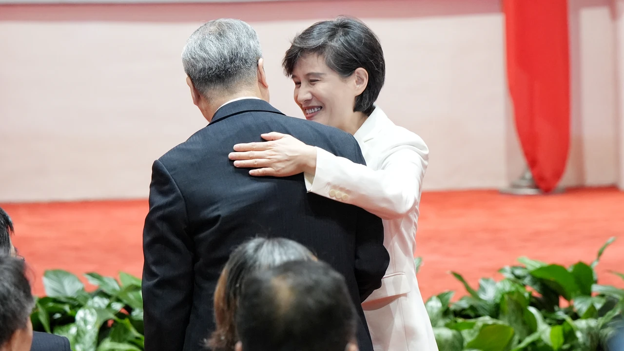 鄭麗君拍龔明鑫肩,感謝老戰友的貢獻。葉志明攝