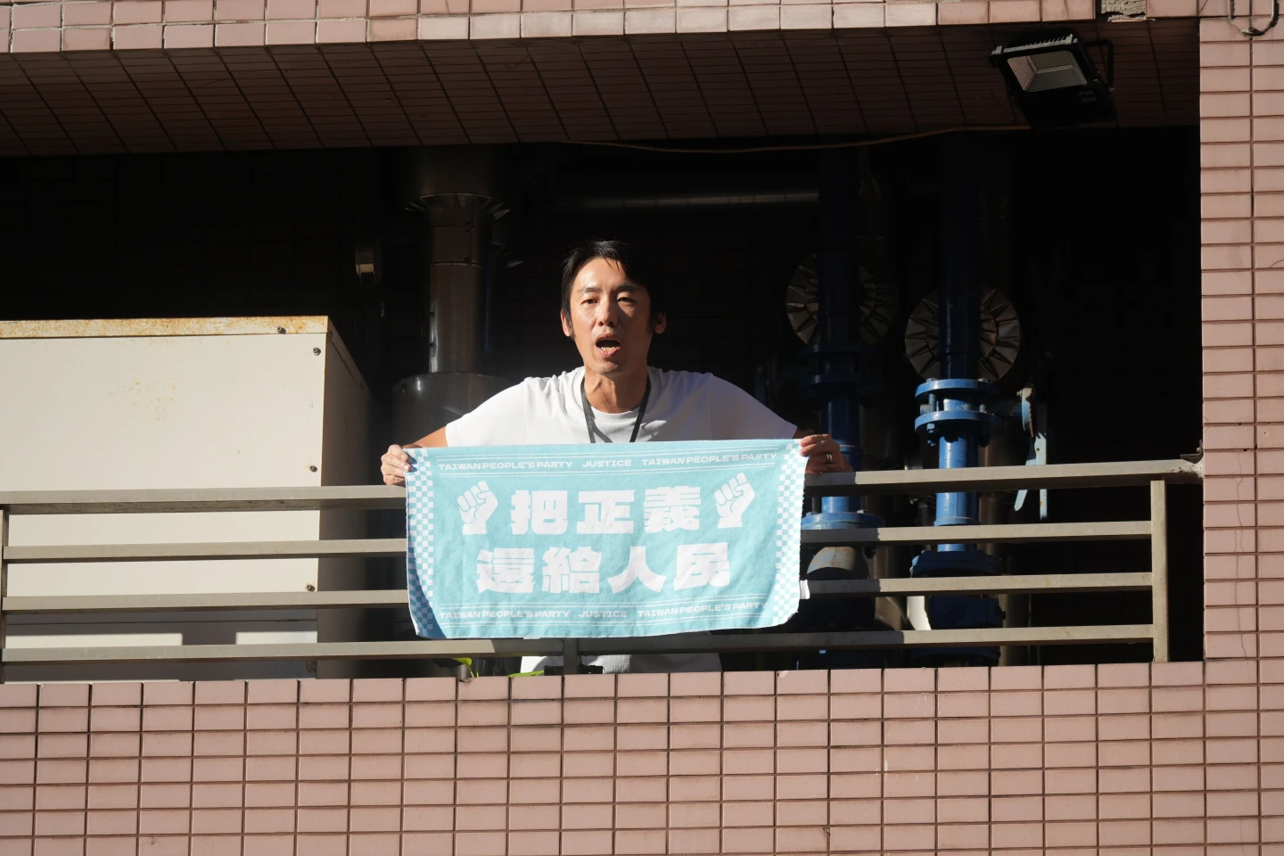 小草高舉「把正義還給人民」的毛巾,向現場媒體高喊「柯文哲清清白白」。陳卓邦攝