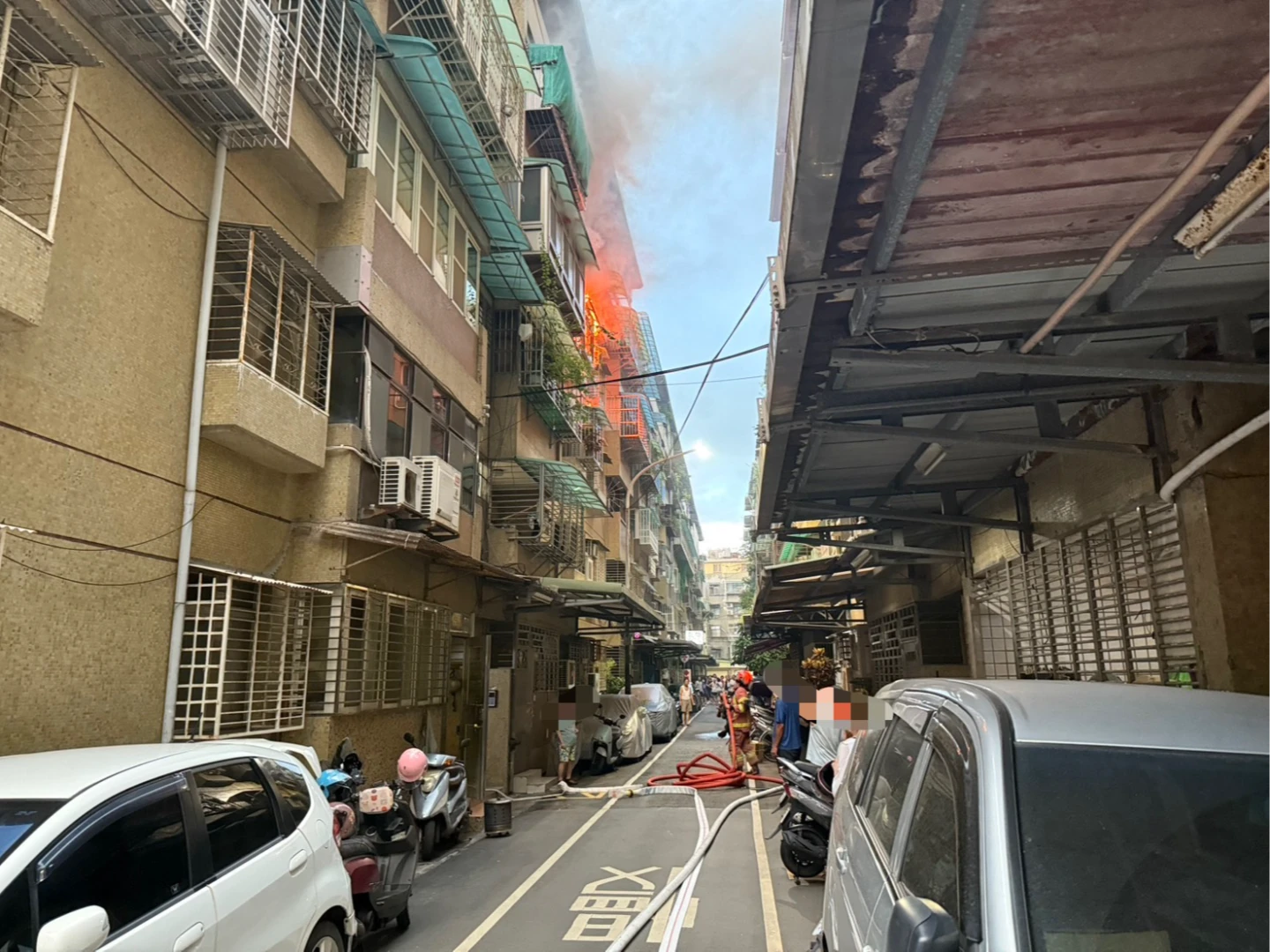 新莊公寓竄出火煙,警消趕緊佈水線搶救。翻攝畫面