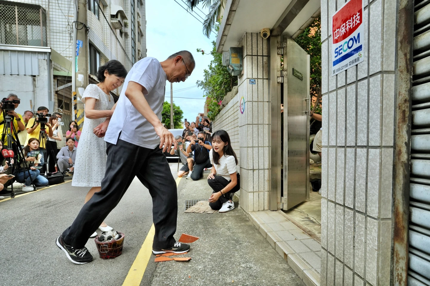 柯文哲回到新竹柯家,柯媽媽準備火爐讓他過火,柯用力踩碎瓦片進入家門,陳佩琪一路牽緊緊。林林攝