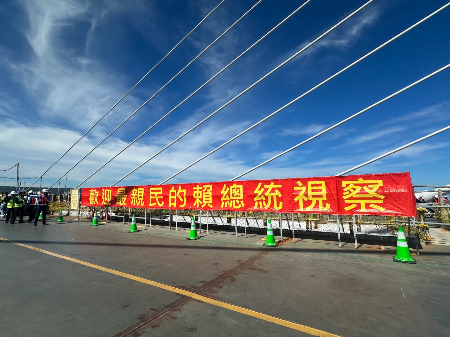 淡江大橋今天舉辦合龍儀式,現場高掛不只一幅紅布條寫著「歡迎最親民的賴總統視察」挨轟拍馬屁。陳怡文攝