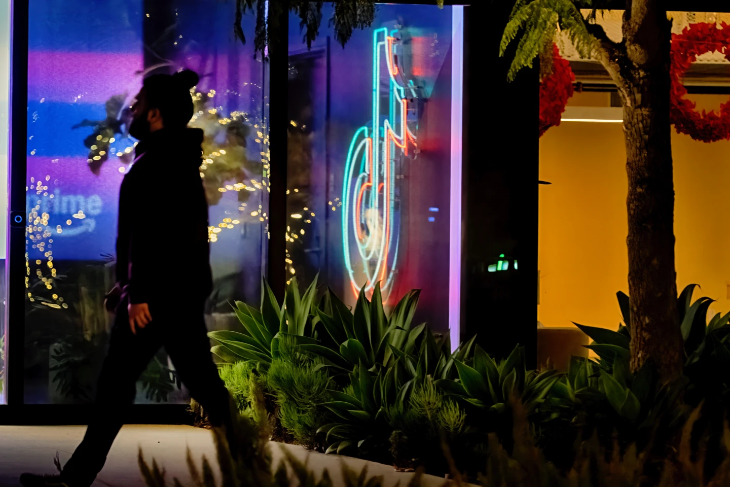 1名人員2024年12月3日走過TikTok加州(Culver City)卡爾弗城辦公大樓大廳,現場裝設TikTok霓虹燈標誌。美聯社