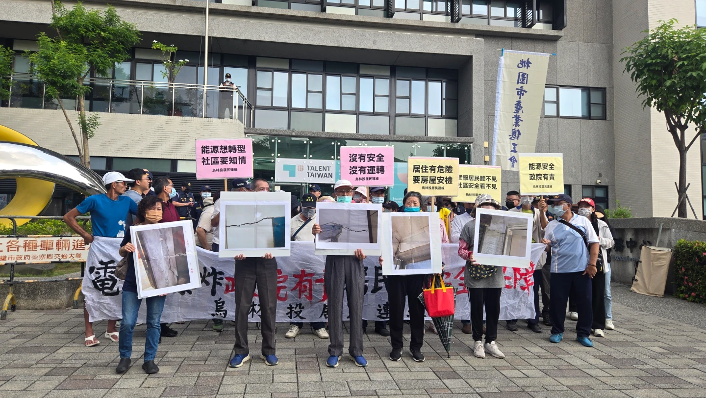 烏林投社區居民展示房屋受損的照片。王勇超攝