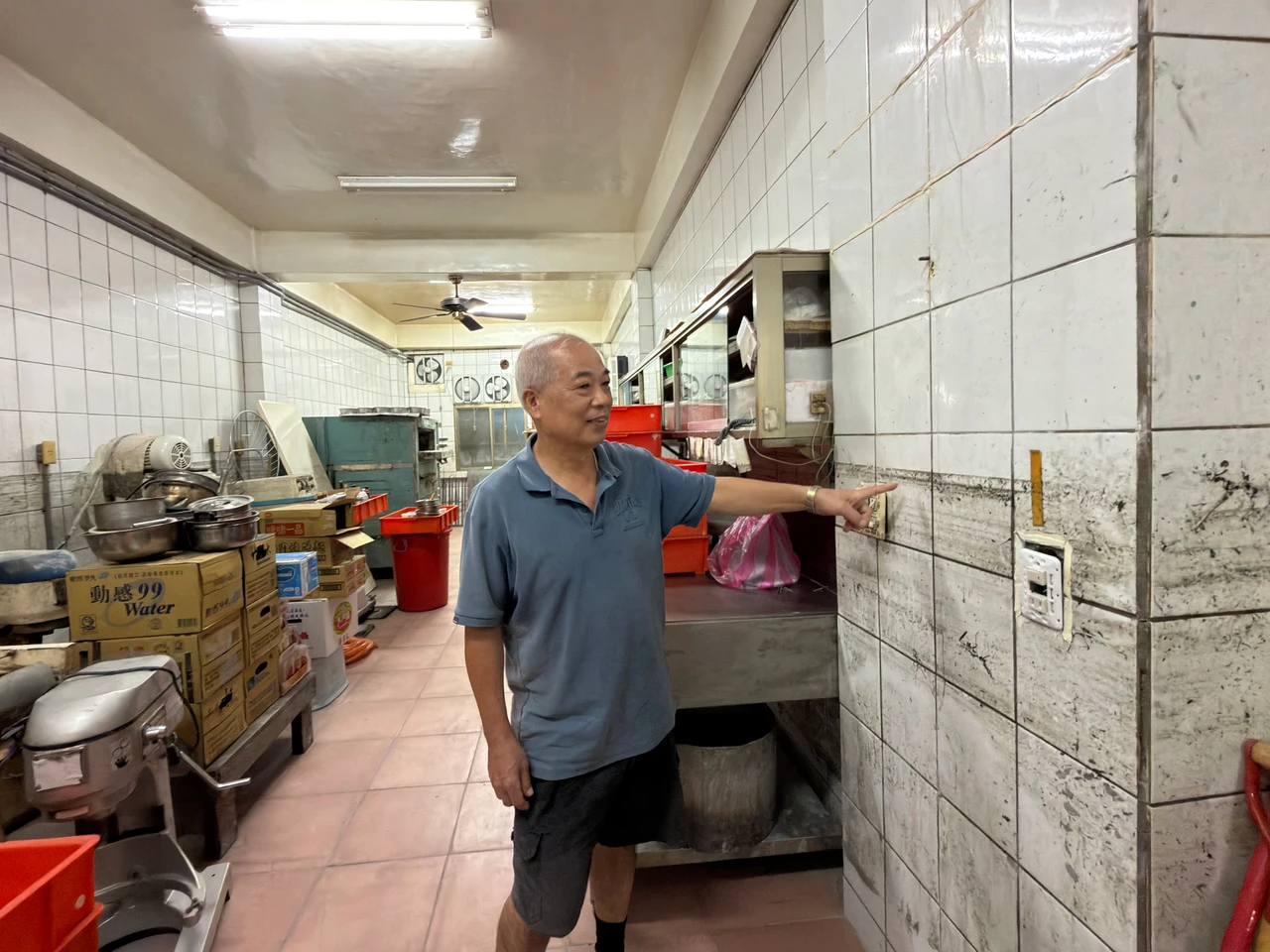 黃銘漳指著牆壁上140公分高的水痕,是當天洪水淹進屋內的高度。沈君帆攝