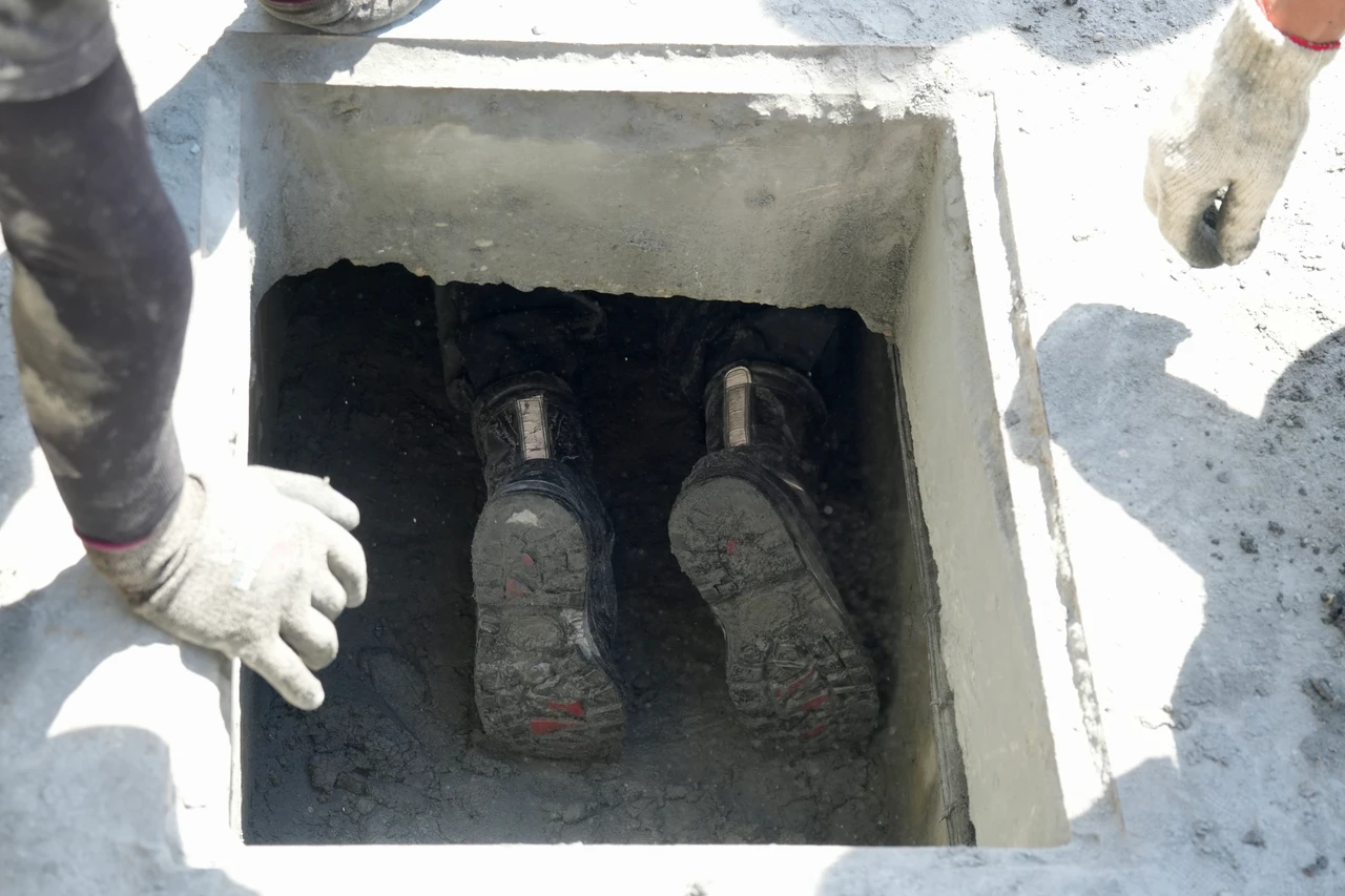志工爬進側溝內查看堵塞狀況。梁建裕攝