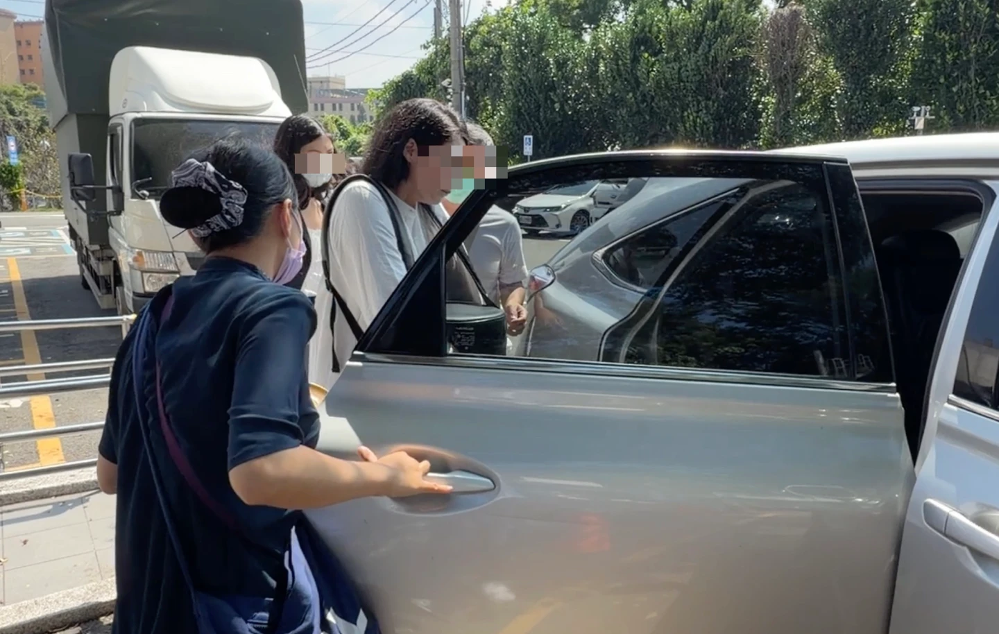 死者胞姊手捧骨灰搭上休旅車,前往潭子晉塔。王煌忠攝