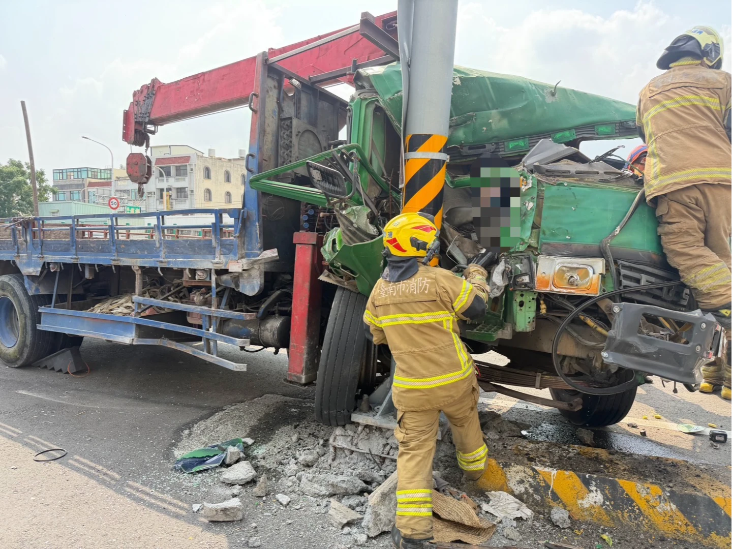 大貨車下橋時不明原因猛撞電桿,副駕駛座女性受困,警消緊急協助搶救。消防局提供