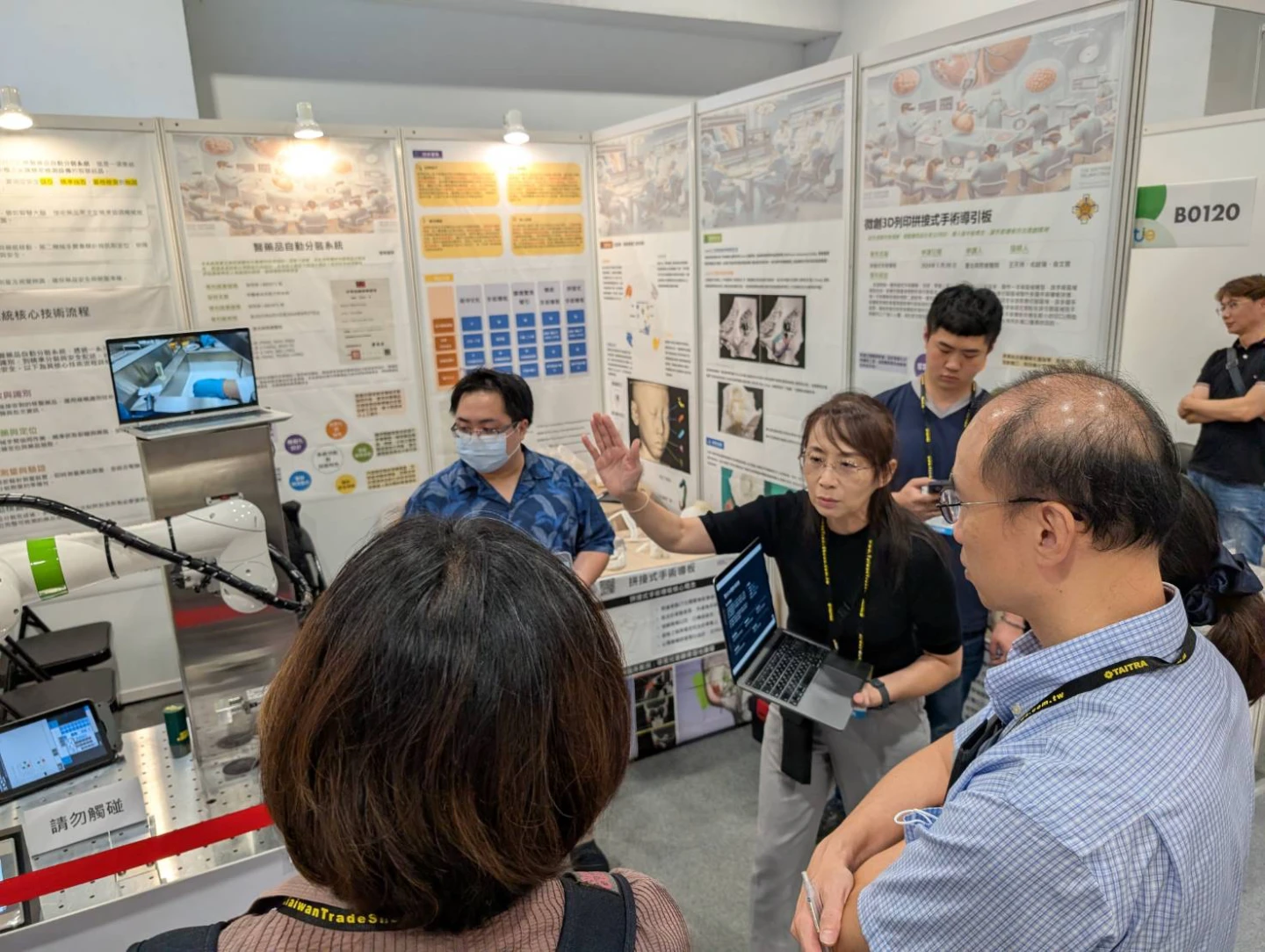 醫學工程室主任陳維聆(中)於展區說明系統作業流程。院方提供