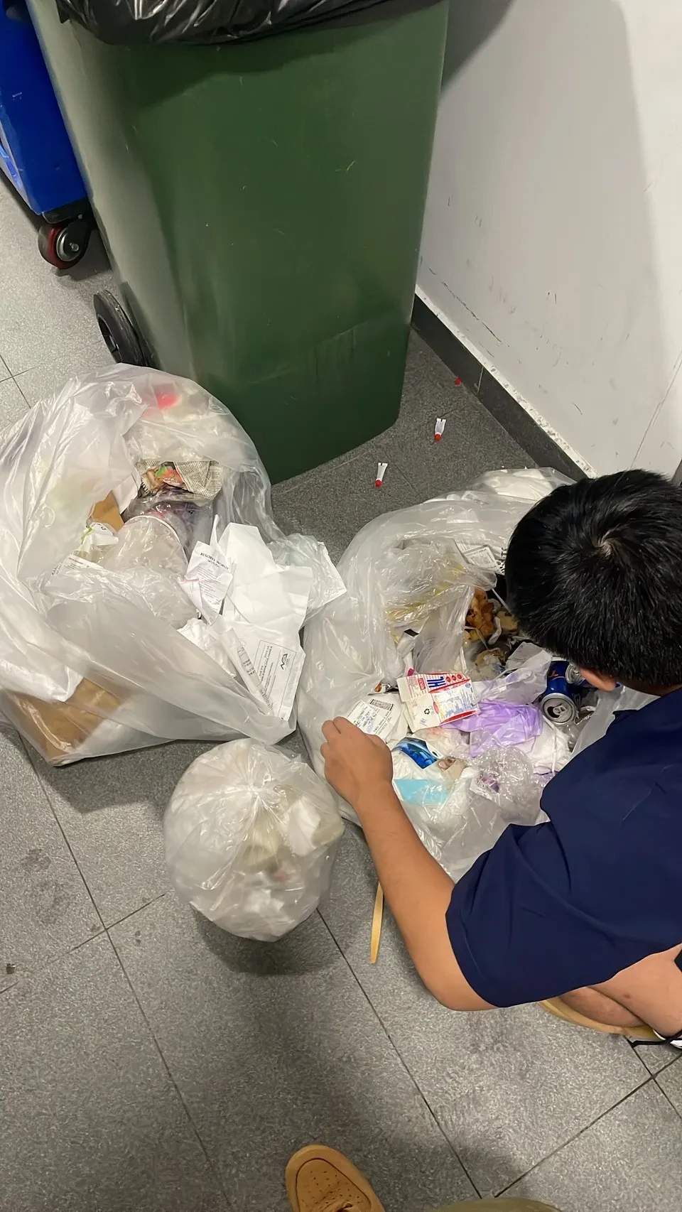 張姓遊客在飯店垃圾堆裡翻找可能遺失的現金。照片為當事人授權使用