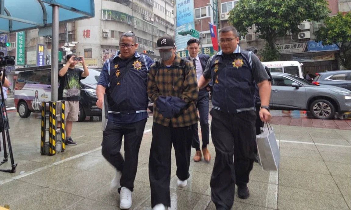 坤達上銬滿臉疲態,走進分局應詢。曾伯愷攝