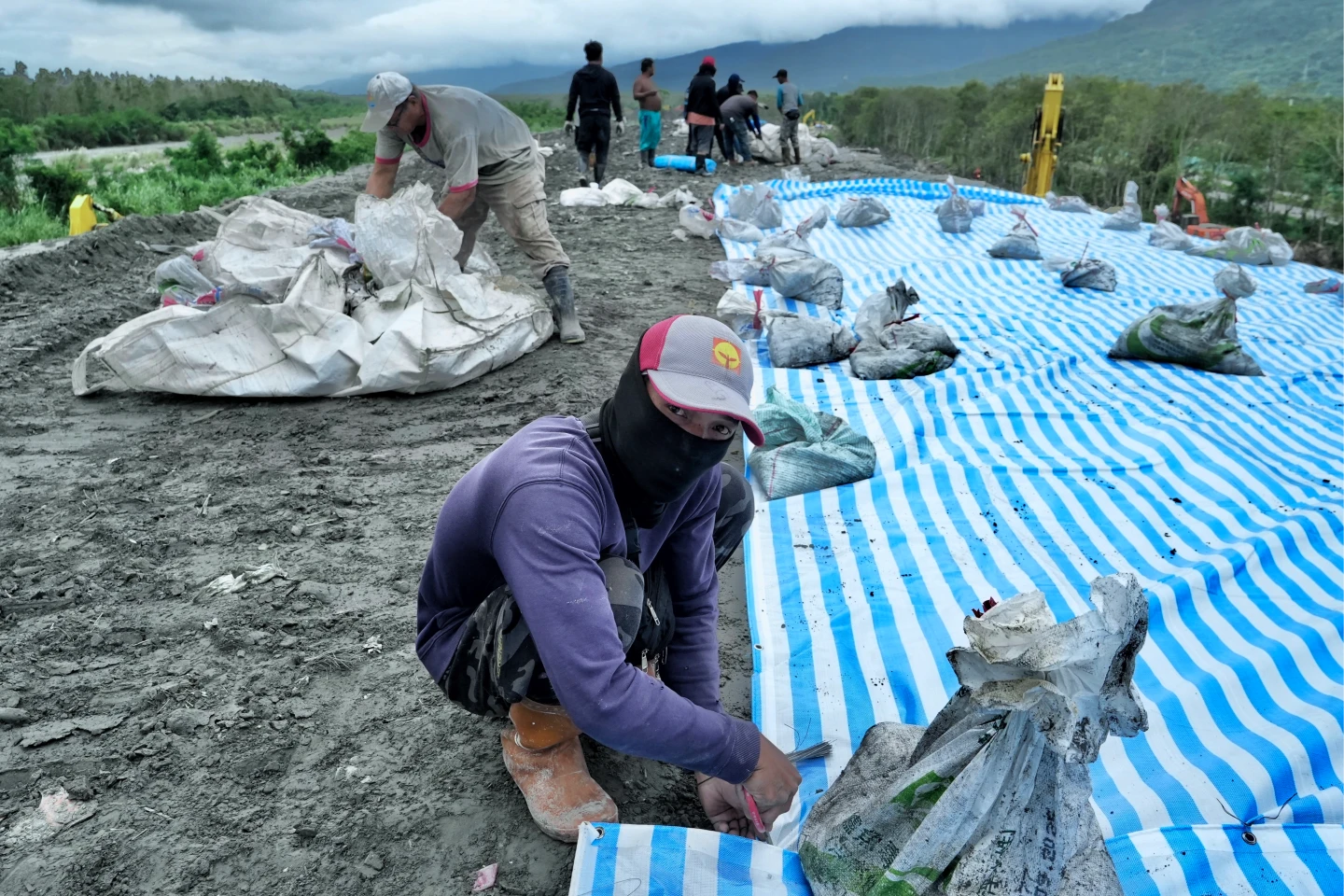 工作人員在土堆上蓋帆布,避免揚塵或雨水沖刷崩落。林林攝