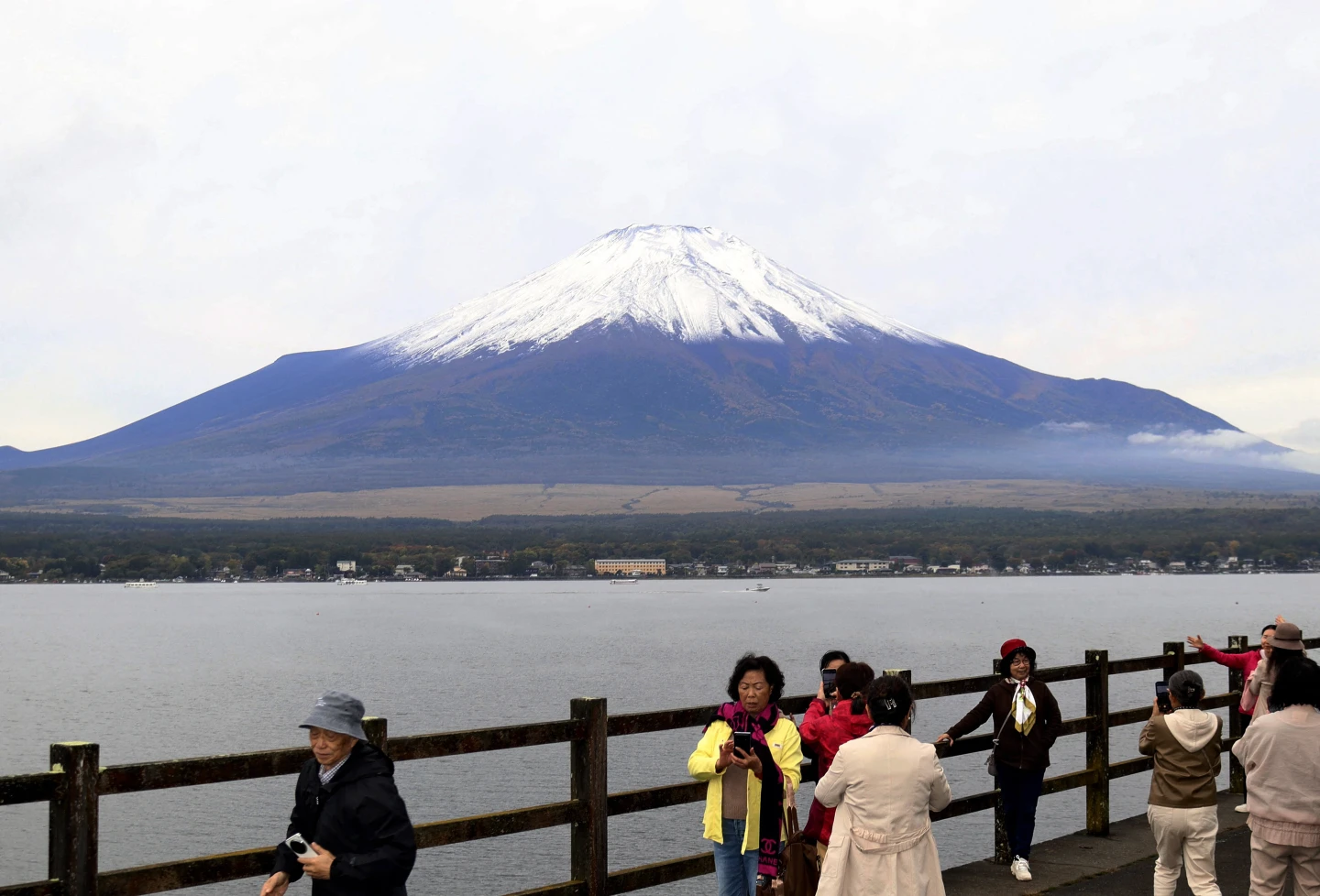 山中湖的遊客10月23日開心與富士山初冠雪合照。法新社