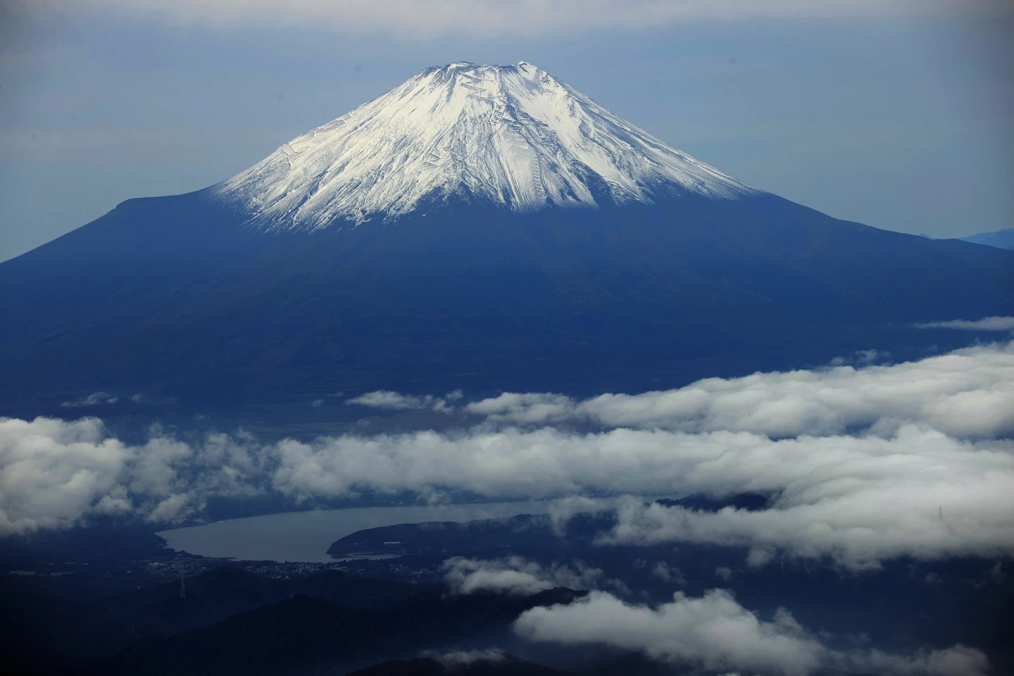 富士山10月23日「初冠雪」,在鄰近湖水與雲霧襯托下顯得十分夢幻。法新社