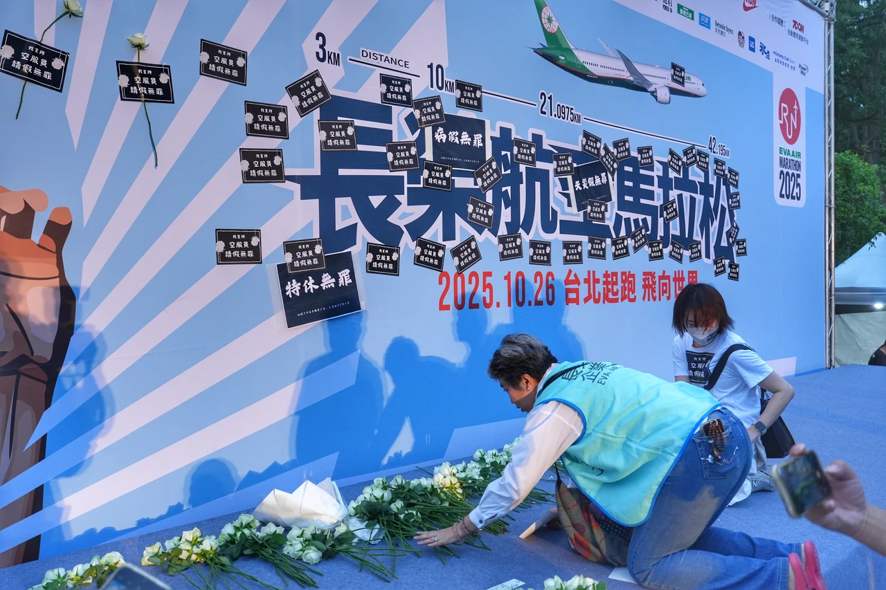長榮馬拉松跑者出發後,空服員工會闖入舞台張貼標語。葉志明攝