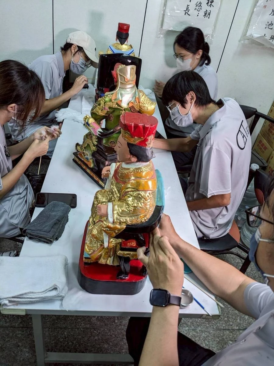 文物志工團隊為神像進行細部清潔與加固。台灣文物保存協會提供